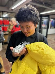 Student holds example of medal fabrication